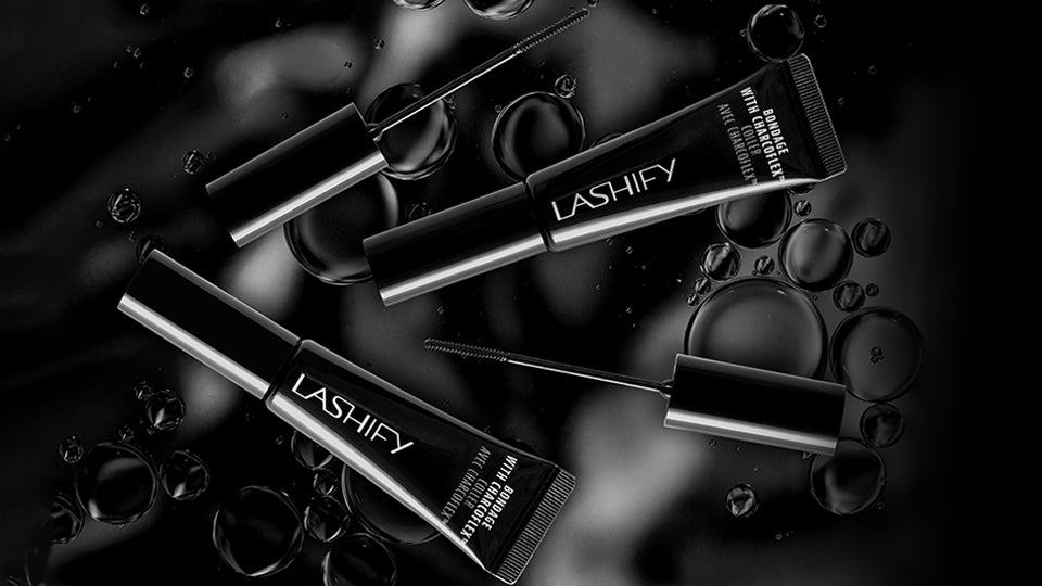 Bottle of Lashify Bondage® extra strength lash bond with charcoal beside Gossamer® lashes